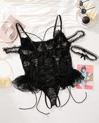 Plus size black lace bodysuit with adjustable straps, floral lace cups, and lace-up detail